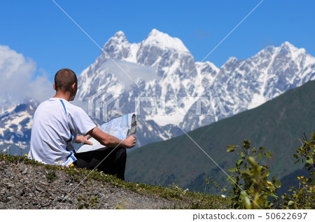 Tourist in the mountains looks at the map Tourist in the mountains looks at the map 50622697