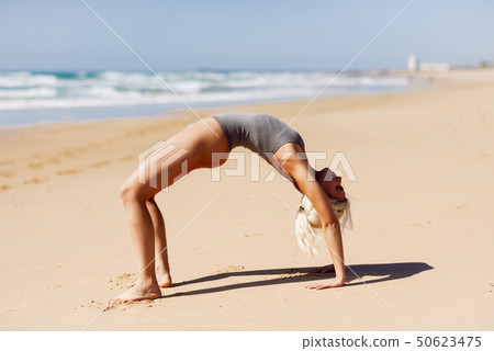 Caucasian blonde woman practicing yoga in the 50623475