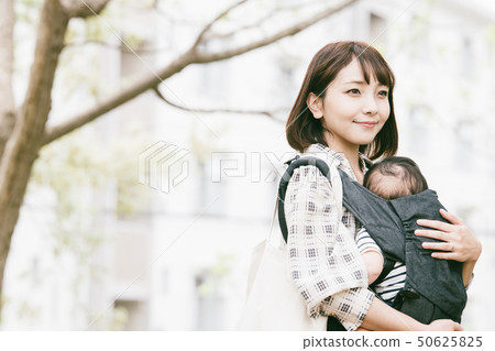 抱著嬰兒的母親新的綠色公園室外擁抱皮帶 抱著嬰兒的母親新的綠色公園室外擁抱皮帶 50625825