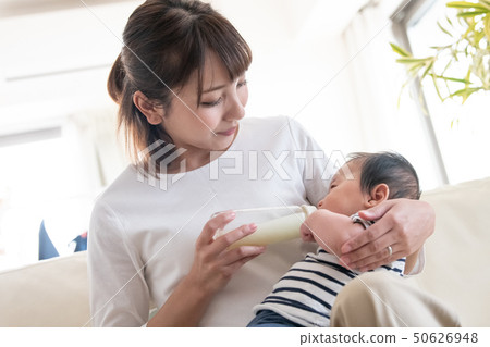 Mother making baby drink milk with baby bottle Mother making baby drink milk with baby bottle 50626948