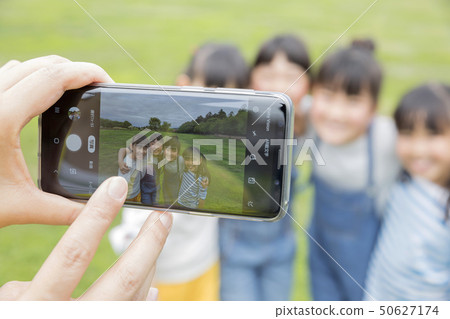 Mother hand to shoot children with smartphone Mother hand to shoot children with smartphone 50627174