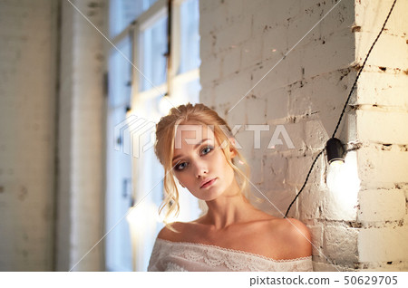 Portrait of a beautiful miniature bride in a lace dress. Hair with curls. Emphasis in make-up on the Portrait of a beautiful miniature bride in a lace dress. Hair with curls. Emphasis in make-up on the 50629705