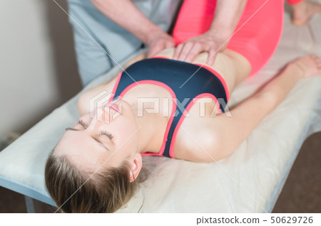 Male manual visceral therapist masseur treats a young female patient. Edit the internal organs and Male manual visceral therapist masseur treats a young female patient. Edit the internal organs and 50629726