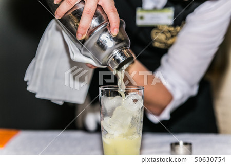 Bartender is making cocktail at bar counter Bartender is making cocktail at bar counter 50630754