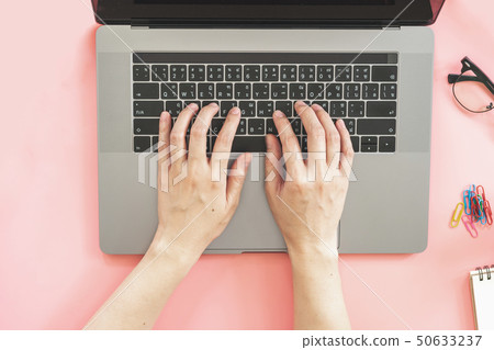Girl typing on laptop in pink pastel colourful 50633237