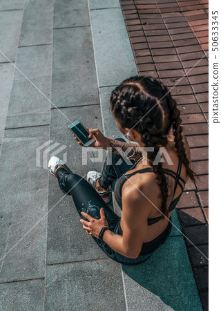 Girl athlete sitting steps resting after workout fitness summer city, day morning. Sportswear, smart Girl athlete sitting steps resting after workout fitness summer city, day morning. Sportswear, smart 50633345