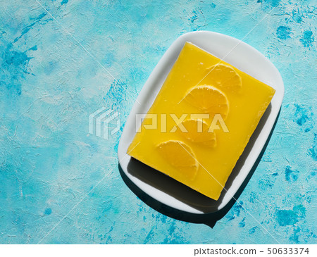 Yellow cheesecake on a bright blue background. Yellow cheesecake on a bright blue background. 50633374