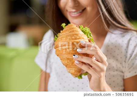 Selective focus of female hand keeping croissant Selective focus of female hand keeping croissant 50635691