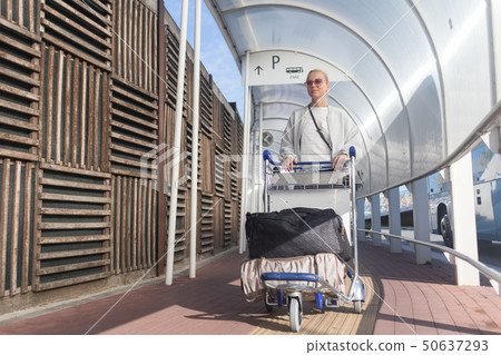 Young woman transporting luggage from arrival parking to international airport departure termainal Young woman transporting luggage from arrival parking to international airport departure termainal 50637293