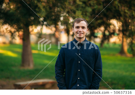 Man in dark blue shirt standing in the park 50637316