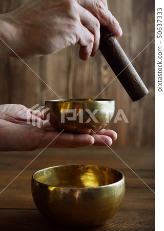 Male hand playing on Tibetan singing bowls Male hand playing on Tibetan singing bowls 50637333