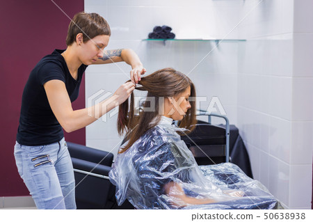 Professional hairdresser doing hairstyle for client Professional hairdresser doing hairstyle for client 50638938