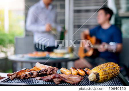 Group of friends Two young man enjoying grilled Group of friends Two young man enjoying grilled 50640130