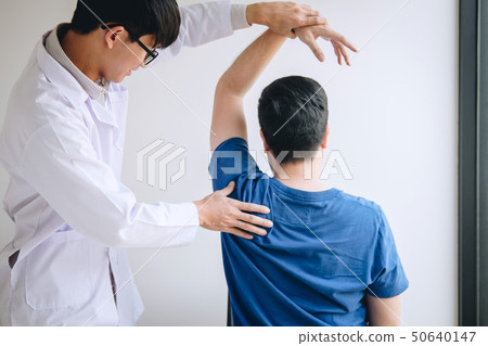 Doctor physiotherapist assisting a male patient Doctor physiotherapist assisting a male patient 50640147