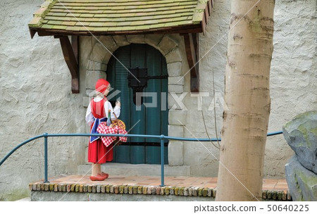 Little Red Hood near the door of a house in Theme Park Efteling. Spring. Little Red Hood near the door of a house in Theme Park Efteling. Spring. 50640225