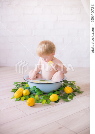 baby boy  in an antique milk bath with fresh fruit 50640728