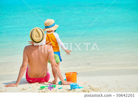 Toddler boy on beach with father Toddler boy on beach with father 50642201