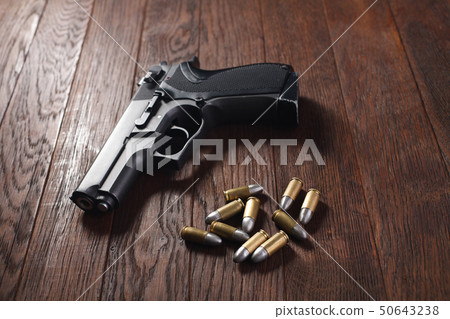 illegal handgun on wooden table 50643238