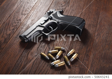 illegal handgun on wooden table illegal handgun on wooden table 50643241