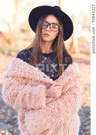 Beautiful girl in a fashionable pink lama coat. Beautiful girl in a fashionable pink lama coat. 50643327