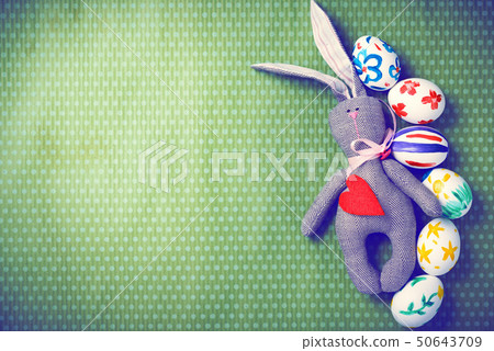Painted Easter eggs on a green background with white polka dots Painted Easter eggs on a green background with white polka dots 50643709