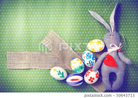Painted Easter eggs on a green background with white polka dots Painted Easter eggs on a green background with white polka dots 50643713