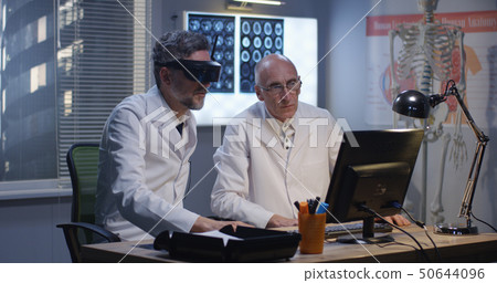 Doctors watching screen using virtual reality headset Doctors watching screen using virtual reality headset 50644096