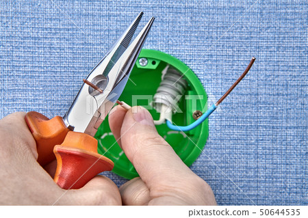 Worker installs round outlet box. 50644535