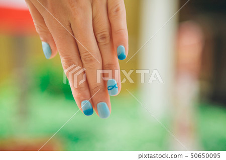 macro: blue manicure with a pattern of fish on the woman's hand. Picture Christian symbol varnish macro: blue manicure with a pattern of fish on the woman's hand. Picture Christian symbol varnish 50650095
