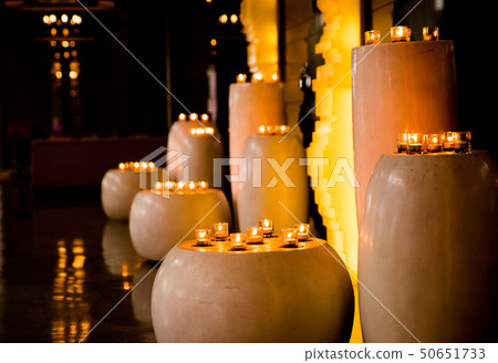 Flame of many candles burning on blurred lights background. Flame of many candles burning on blurred lights background. 50651733
