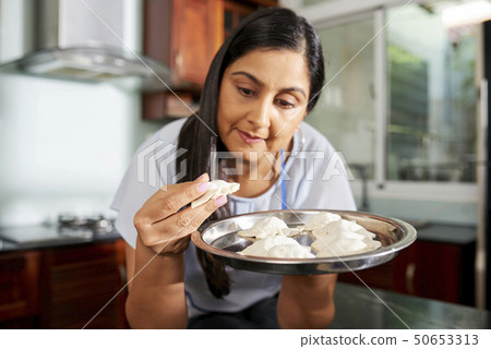 Woman enjoying cooking ravioli Woman enjoying cooking ravioli 50653313