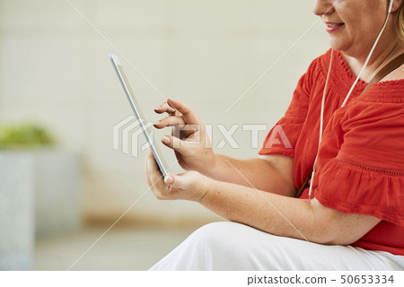 Woman zooming in video on tablet 50653334
