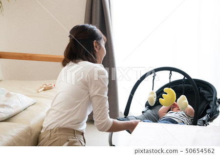 Mother raising a baby in a bouncer Mother raising a baby in a bouncer 50654562
