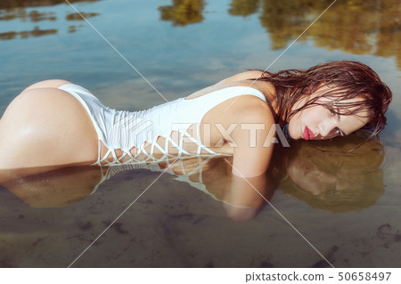 Beautiful woman lying in the water. Beautiful woman lying in the water. 50658497