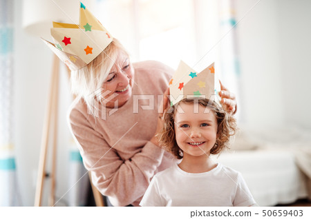 A portrait of small girl with grandmother at home, having fun. A portrait of small girl with grandmother at home, having fun. 50659403