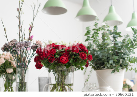 flower shop concept. Vases with different flowers on wooden table. Wallpaper 50660121