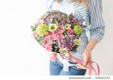 cute bouquet of mixed flowers in womans hands. the work of the florist at a flower shop. Delicate cute bouquet of mixed flowers in womans hands. the work of the florist at a flower shop. Delicate 50660291