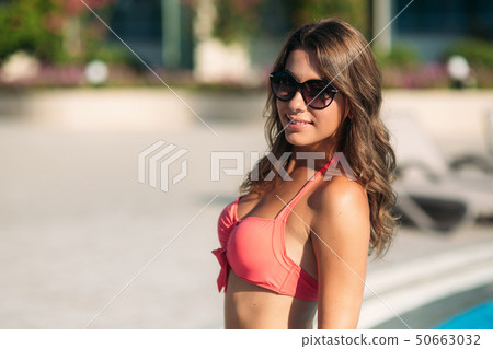 Sexy woman in bikini enjoying summer sun and tanning during holidays in pool 50663032
