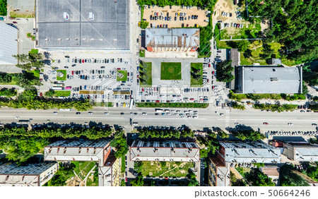 Aerial city view with crossroads and roads, houses, buildings, parks and parking lots. Sunny summer 50664246