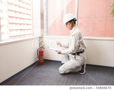 檢查滅火器的工作者 檢查滅火器的工作者 50666670