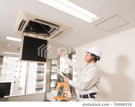 Workers checking the air conditioning in the office Workers checking the air conditioning in the office 50666858
