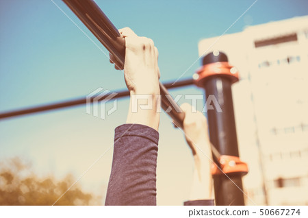 Closeup of a teenager's hands on a horizontal bar 50667274