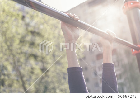 Closeup of a teenager's hands on a horizontal bar 50667275