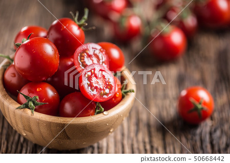 Fresh cherry tomatoes in wooden bowl on old oak 50668442