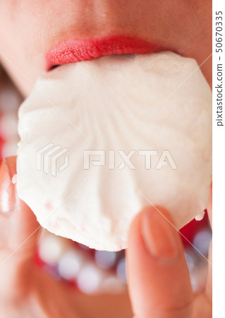 Woman eating marshmallow. Woman eating marshmallow. 50670335