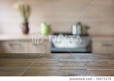 Blurred kitchen background with wooden tabletop. Blurred kitchen background with wooden tabletop. 50673276