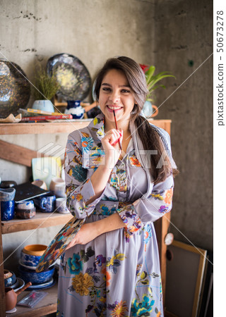 Beautiful lady artist standing in her studio, creative business owner Beautiful lady artist standing in her studio, creative business owner 50673278