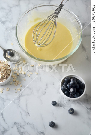 Mixing eggs,flour and milk in bowl with wire whisk Mixing eggs,flour and milk in bowl with wire whisk 50673602