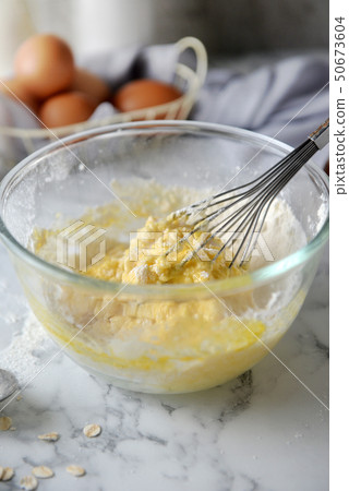 Mixing eggs and flour in bowl. 50673604