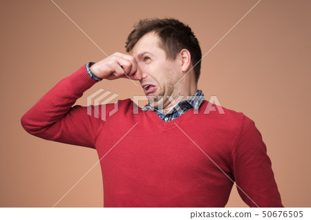 Man plugs nose as smells something stink Man plugs nose as smells something stink 50676505